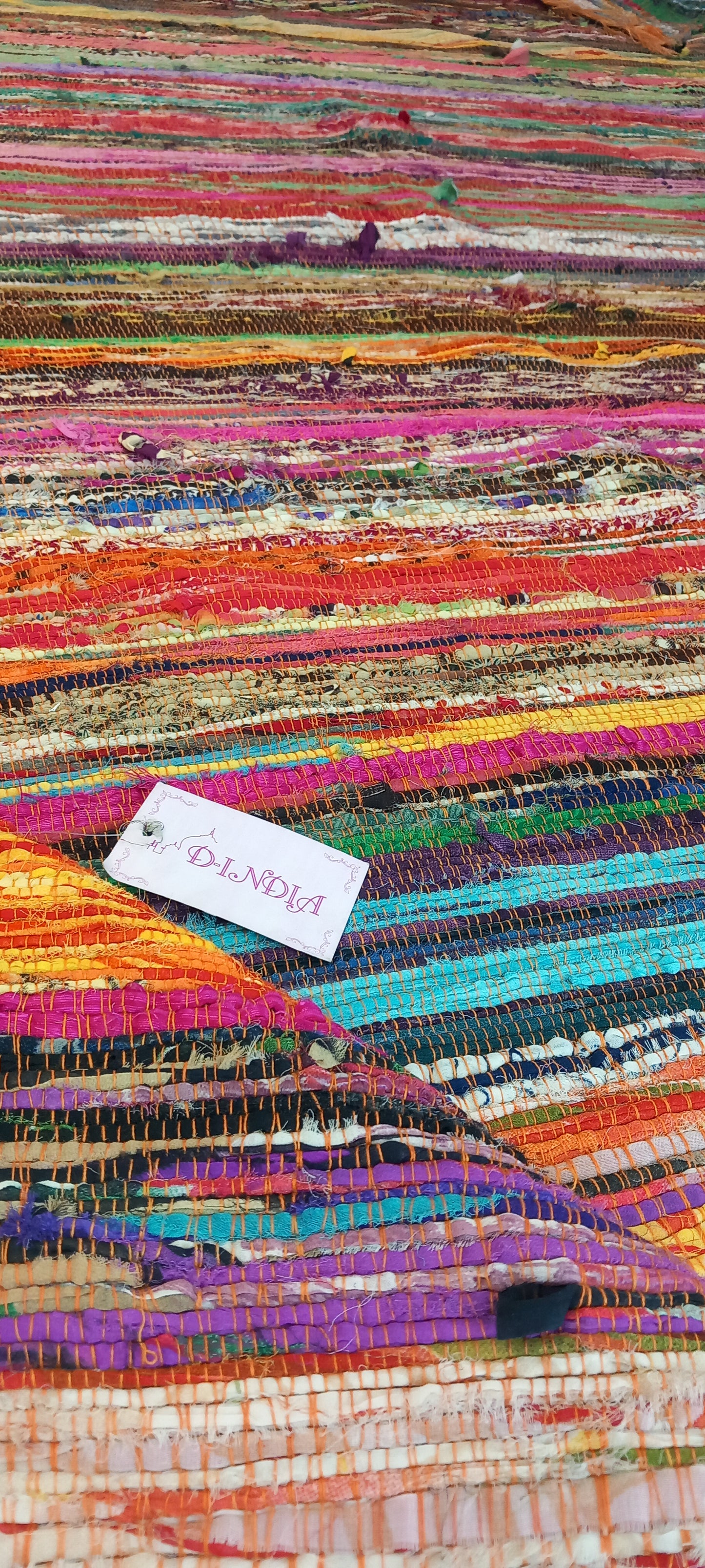 Una explosión de color, textura y tradición en una sola pieza. La jarapa multicolor de 100x200 cm está elaborada artesanalmente con retales de algodón teñidos con tintes naturales, lo que da como resultado una alfombra única, vibrante y cargada de carácter. Su diseño mezcla tonos de forma armónica, creando un efecto visual atractivo y cálido. Además de usarse como alfombra, es perfecta como tapiz de pared, cubrecama o para renovar el estilo de muebles y sofás.