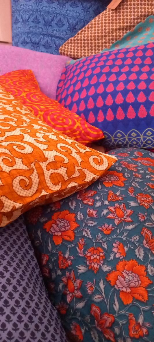 La Funda de Cojín Saree 40x40 cm es una pieza artesanal que combina elegancia, sostenibilidad y exclusividad en cada detalle. Confeccionada con telas sedosas recicladas de saree, cada funda es única gracias a sus colores vibrantes y estampados irrepetibles. 