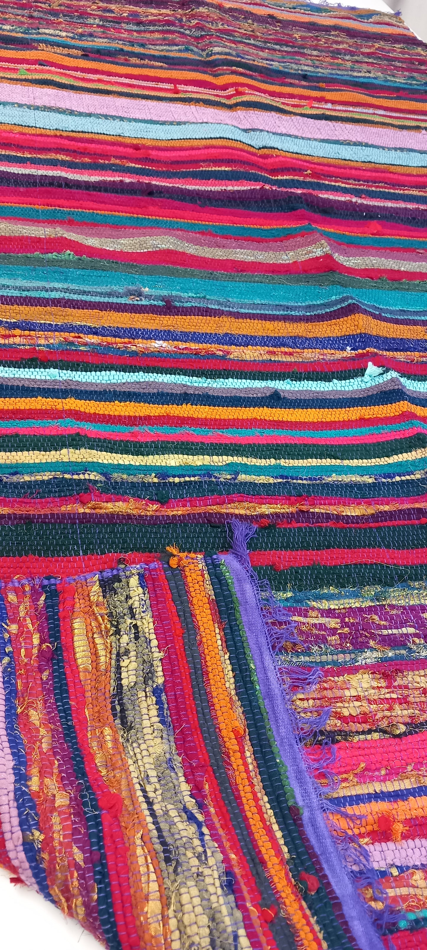 Una explosión de color, textura y tradición en una sola pieza. La jarapa multicolor de 100x200 cm está elaborada artesanalmente con retales de algodón tratados con tintes naturales, lo que da como resultado una alfombra única, vibrante y cargada de carácter. Su diseño mezcla tonos de forma armónica, creando un efecto visual atractivo y cálido. Además de usarse como alfombra, es perfecto como tapiz de pared, cubrecama o para renovar el estilo de muebles y sofás.