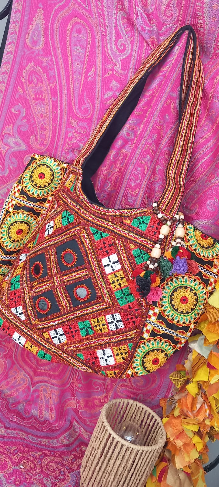 bolso Frame Iro Bangalore con abalorios es una pieza original, amplia y con carácter, ideal para ofrecer un toque de exclusividad y color en tu vida. Su diseño tipo capazo destaca por su gran capacidad y su estampado diferente bordado con espejitos con hilos de colores sobre una base negra, creando un contraste vibrante y único. Cuenta con dos asas cómodas para llevar al hombro, cierre de cremallera y bolsillo interior, combinando funcionalidad y estilo. Además lleva un toque de distinción con los encantado