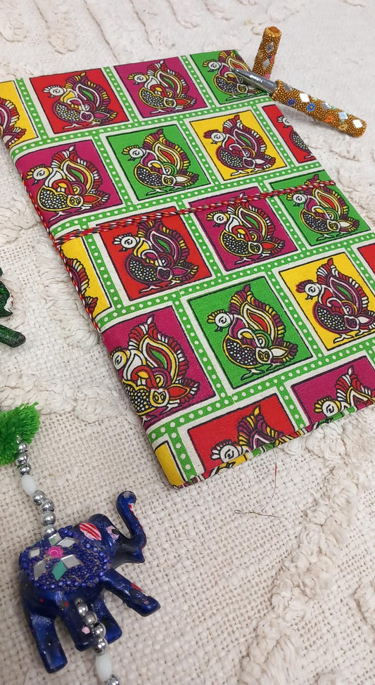 Un cuaderno que es mucho más que una libreta: una pieza de arte y tradición. La Libreta Faisán sagrado destaca por su cubierta con ilustraciones de faisanes hindúes y budistas, ave sagrada nacionalmente de la India es símbolo espiritual que simboliza amor, compasión e inmortalidad evocando calma y conexión. Con papel reciclado de buen gramaje, es perfecto para escribir, dibujar o plasmar ideas con un toque auténtico y artesanal. Un complemento ideal para quienes buscan espiritualidad y belleza en cada detal