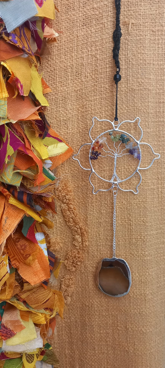 Una pieza armoniosa para el alma y los sentidos. Este colgador móvil de viento combina minerales y metal en un diseño artesanal con gran carga estética y natural. Su flor de loto central tallada con árbol y minerales sostiene varios tubos de cobre y minerales decorativos con piedras naturales sin pulir reales colgantes y el ágata colgante que, al moverse con la brisa, produce un ambiente suave y relajante. Una pieza ideal para llenar de calma y energía positiva cualquier espacio, tanto interior como exterio