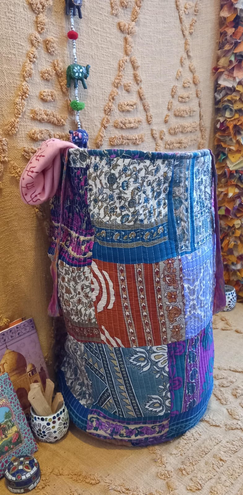 El Cesto Wild Saree 35x50 cm es una pieza artesanal multifuncional que destaca por su exclusividad, sostenibilidad y versatilidad. Confeccionado con telas sedadas recicladas de saree y yute, cada cesto es único gracias a sus vibrantes colores y estampados elaborados con la técnica de patchwork. Su diseño práctico y amplio permite utilizarlo como bolso, elemento decorativo o almacenamiento para el hogar, aportando un toque auténtico de artesanía india a cualquier espacio.