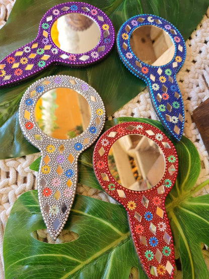 PACK DE 2 ESPEJOS DE CRISTALITOS.

El espejo cristalitos con mango es un accesorio encantador, práctico y con ese toque artesanal que lo hace especial. De forma redonda y con 7 cm de diámetro, está decorado con brillantes cuentas y pequeños espejos incrustados a mano, aportando un aire festivo y único. Su pequeño mango lo hace cómodo de usar, y su tamaño compacto es perfecto para llevar siempre en el bolso. Una propuesta ideal para personas que quieren conseguir pequeños detalles llenos de alma y color.