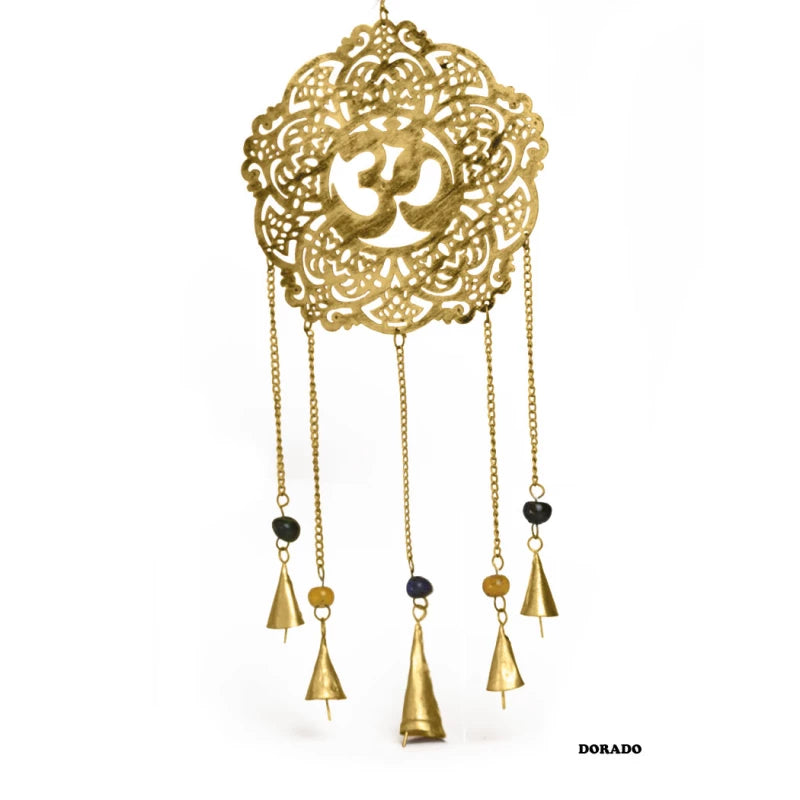 Un objeto decorativo con simbolismo profundo y belleza artesanal. El colgador metálico Atrapasueños con Om, elaborado en tono dorado apagado, une dos poderosos símbolos de la espiritualidad india: el mantra Om. Forma redondeada desde donde cuelgan cinco cadenas de diferentes longitudes decoradas con abalorios de cristal y terminaciones con campanas.Con una longitud aproximada de 67 cm y 22 cm de diámetro, este colgador no solo embellece cualquier espacio, sino que también genera un suave y relajante tintine