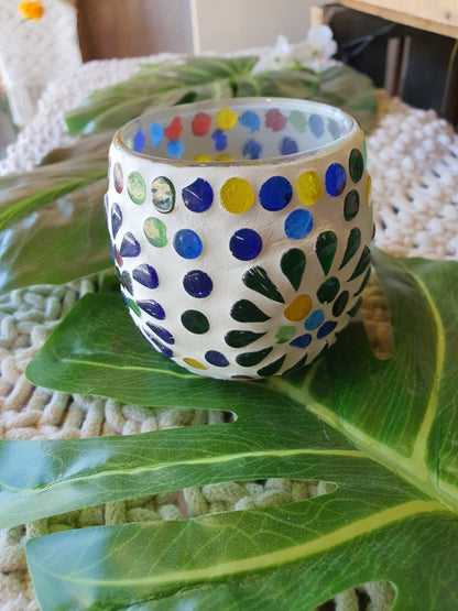 Este portavelas es una pequeña joya de vidrio que transforma cualquier espacio en un rincón mágico. Su mosaico de cristales de colores refleja la luz de la vela con un encanto único, creando una atmósfera cálida y especial. Cada pieza, aunque similar en estilo, tiene una personalidad propia gracias al trabajo minucioso y artesanal que las define. Perfecto para personas que desean decoración con alma, este accesorio se convierte en un detalle inolvidable para quienes buscan belleza en lo cotidiano.
E.GRATIS